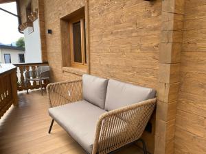 格英Wood Apartments by Trendlbrugger的藤椅,坐在带墙壁的门廊上
