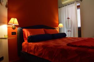 阿格里真托B&B Le Casette Di Lù的一间卧室配有一张带橙色墙壁的床和两盏灯。