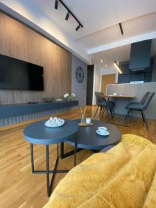 贝尔格莱德DOM Boutique Apartments - Park View的客厅配有两张桌子和一张沙发