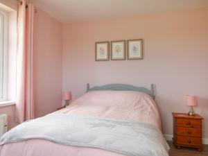 彭赞斯Driftwood的一间卧室配有一张带两盏粉色灯的床