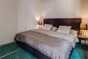 弗里代克-米斯泰克格言酒店的一间卧室配有一张大床和两盏灯