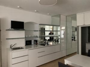 雷根斯堡金色克鲁兹酒店的一间厨房,配有白色橱柜和墙上的电视