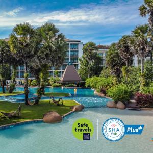 奈通海滩Naithonburi Beach Resort - SHA Extra Plus的棕榈树度假村的游泳池以及大楼