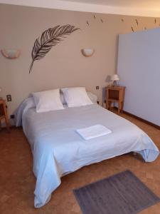 马泰马尔大草原旅馆的卧室配有白色床和墙上的羽毛
