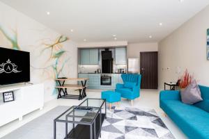 吉林汉姆Chic & Comfortable Serviced Apartment的客厅配有蓝色的沙发和电视