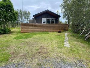 SkogarCabin in the lava. Near Húsavík的一座小房子,位于一座小山上,有草地庭院