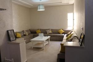纳祖尔Panorama Apartment Nador Jadid Klima free Parking & Wifi的客厅配有沙发和桌子