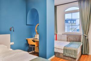 佩奇Benelux Hotel的一间卧室配有一张床、一张书桌和一个窗户。