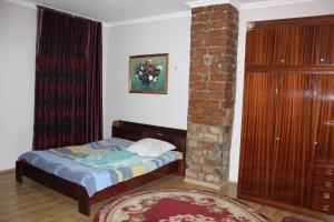 TsinandaliKera的一间卧室配有一张床和一个砖柱