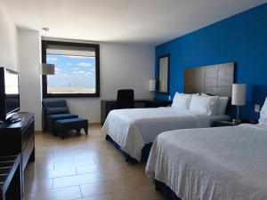 梅里达Holiday Inn Express Mérida, an IHG Hotel的酒店客房设有两张床和电视。