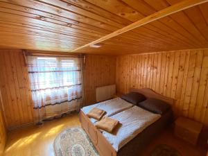 沃洛韦齐Pid Playem的木制客房内的一间卧室,配有一张床
