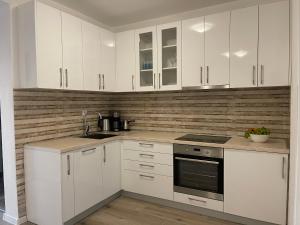 RavanjVilla Roki的厨房配有白色橱柜和炉灶烤箱。