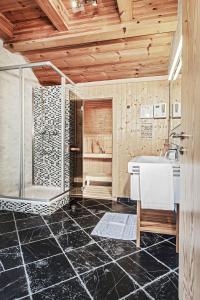 滨湖采尔Chalet Dacha mit finnischer Sauna的带淋浴、盥洗盆和浴缸的浴室