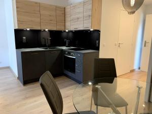 迪沃讷莱班Très bel appartement T2 de standing entièrement meublé à 5 min à pied du centre.的一个带玻璃桌和椅子的大厨房