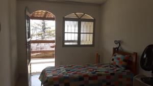 萨夸雷马Recanto do Surf的一间卧室设有一张床和一个开放式窗户。
