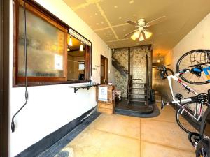 尾道市島宿Nest的一间带吊扇的客房和墙上的自行车