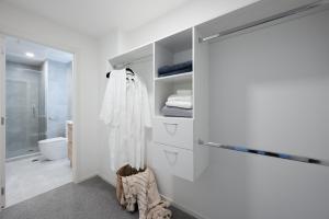 奥克兰Sunrise Garden Serviced Apartments Albany的一间带白色墙壁和推拉门的浴室