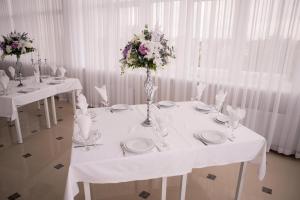 日托米尔Отель-ресторан “Le Grand”的一张带盘子和鲜花的白色桌子