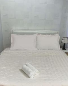 胡志明市Hoang Tuan Hotel的一张白色的床,上面有两条滚毛巾