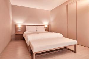 宁越Tops10 Resort Donggang Cistar的卧室配有白色大床和长凳