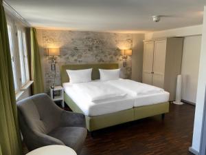 爱尔福特克拉默布鲁克爱尔福特酒店的卧室配有一张白色大床和一把椅子