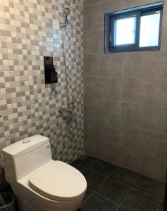 冬山乡富英农舍·莫兰迪色系主题防空洞的一间带白色卫生间的浴室和窗户。