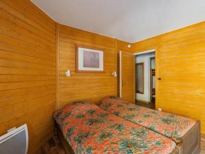 布里德莱班Studio Brides-les-Bains, 1 pièce, 4 personnes - FR-1-512-227的卧室设有木墙和一张床。
