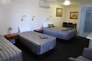 查尔维尔沙勒维尔丛林汽车旅馆的酒店客房设有两张床和一张桌子。
