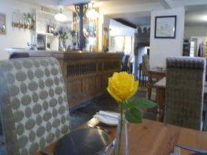 West Bradford3 Millstones Inn的黄花在桌子上的花瓶里