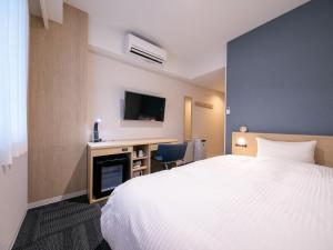 高知Hotel Best Price Kochi的配有一张床和一张书桌的酒店客房