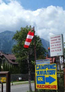 布什泰尼Camping Aviator Busteni, camere的标志和建筑物旁的柱子上的旗帜