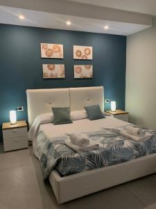 切萨雷奥港Albergo Piazza Risorgimento的卧室配有白色床和蓝色墙壁