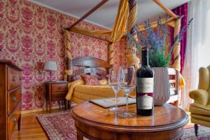 ElenovoHotel Soli Invicto的桌子上放有一瓶葡萄酒和两杯酒