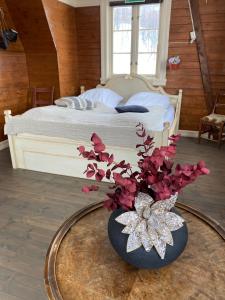 特罗姆瑟Kræmarvika Lodge的一间卧室配有一张床,一个花瓶摆放在桌子上