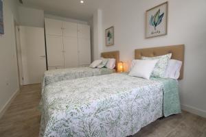 马拉加Del Parque Flats Puerto的一间卧室配有两张床和一盏灯。