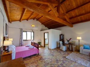 Montalbano IonicoMasseria Crocco的卧室设有粉红色的床和木制天花板。