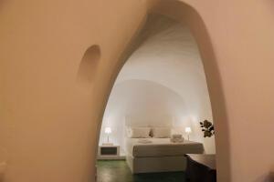 梅加洛克里Hiraeth Santorini的一间卧室设有一张床和一个拱形门廊