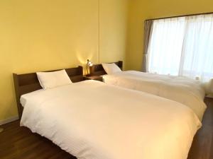 宫古岛Hotel Shion no Umi - Vacation STAY 97912的带窗户的客房内的2张白色床