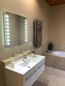 帕尔橡树旅舍的浴室配有盥洗盆、镜子和浴缸