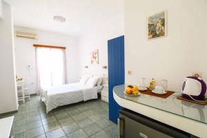 卡马利Finikas Santorini的带卧室、床和厨房的客房