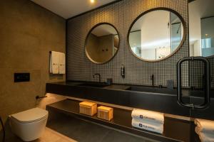 里斯本Ferraria XVI FLH Hotels Lisboa的一间带水槽、卫生间和镜子的浴室