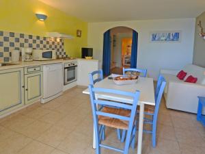 韦基奥圣露西港口La Côte Bleue的厨房以及带桌椅的起居室。