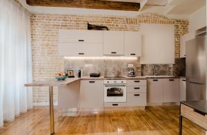 科孚镇Curcumelli Luxury Suites - ΚΟΡΚΥΡΑ的一间厨房,配有白色家电和砖墙