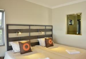 乌姆德洛蒂格林费尔海豚海岸旅馆的一间卧室配有一张大床和镜子