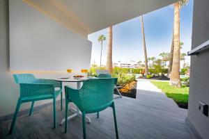 英格兰海滩普拉西娅洛格拉斯勒酒店的一个带桌椅和棕榈树的庭院