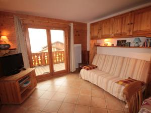 维拉尔叙尔多龙Appartement Villard-sur-Doron, 3 pièces, 6 personnes - FR-1-293-254的一间卧室配有一张床、一台电视和一个阳台