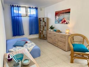 阿尔巴塔克斯Villa SERF a 100 m dalla spiaggia的一间卧室配有床和一个带蓝色窗帘的梳妆台。