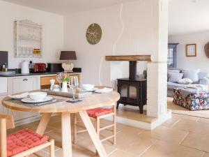 查尔伯里Apple Store Cottage的厨房以及带桌子和炉灶的客厅。