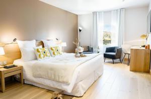纳博讷Château L'Hospitalet Wine Resort Beach & Spa的卧室配有一张白色大床和一张书桌