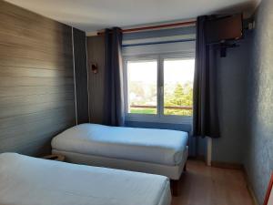 塞科斯Hôtel des îles的小房间设有两张床和窗户
